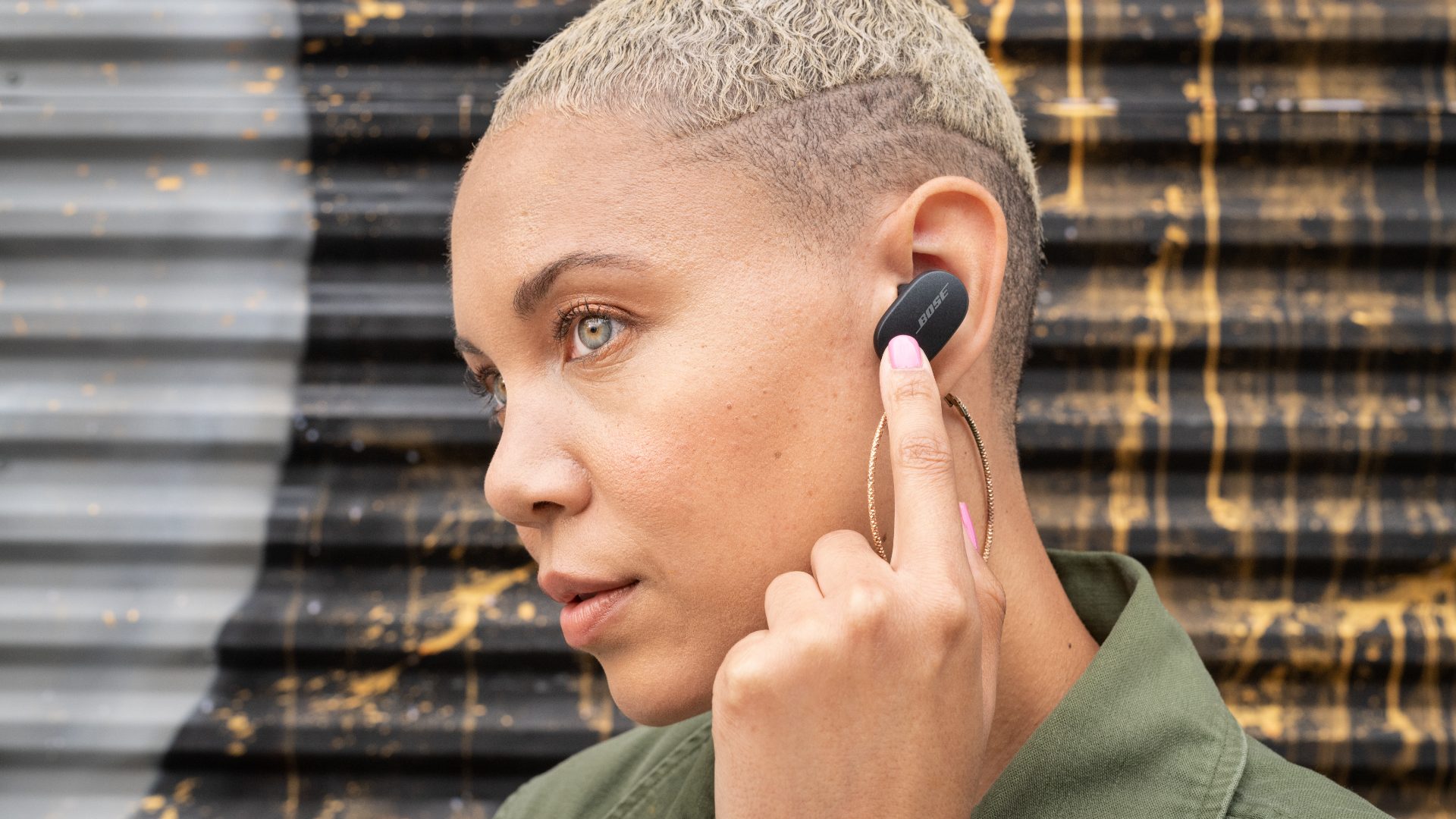 Blonde girl shows bluetooth earbuds