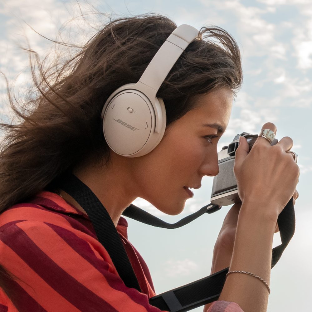 Girl with camera and Bose headphones listen the music