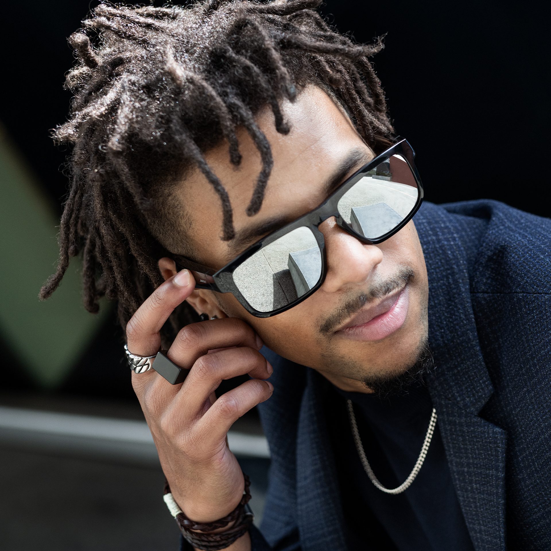 A man with dreadlocks and audio sunglasses